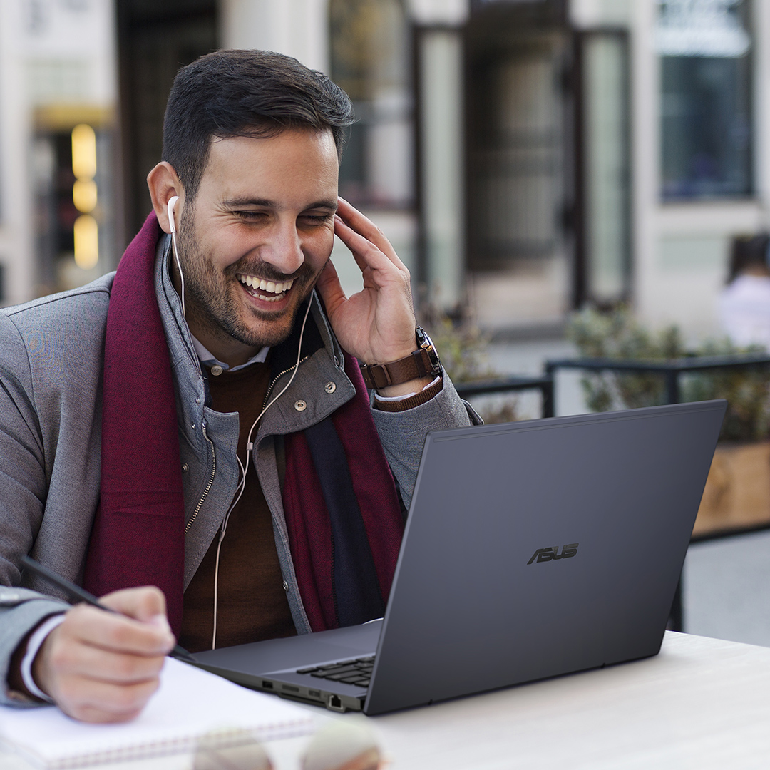 Två affärsmän tittar på ASUS Chromebook Avtagbar tillsammans med ett leende.